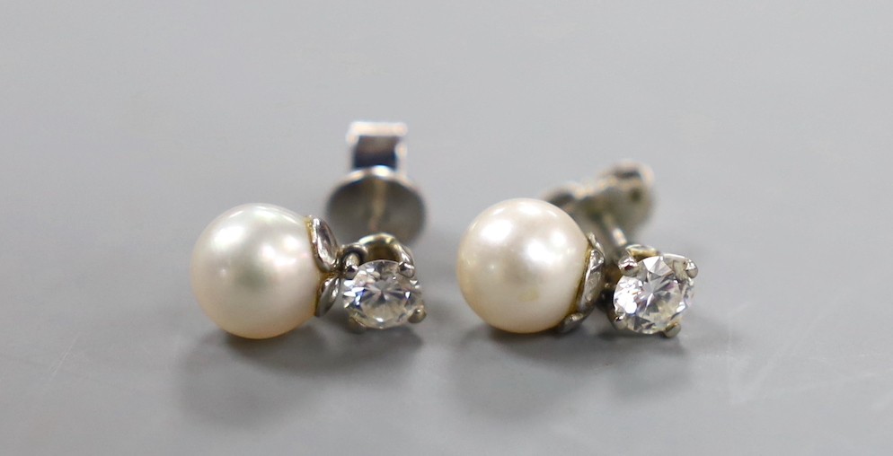 A pair of white metal cultured pearl and single stone diamond set ear studs (butterflies differ) pearl diameter 6.8mm, gross weight 2.7 grams.